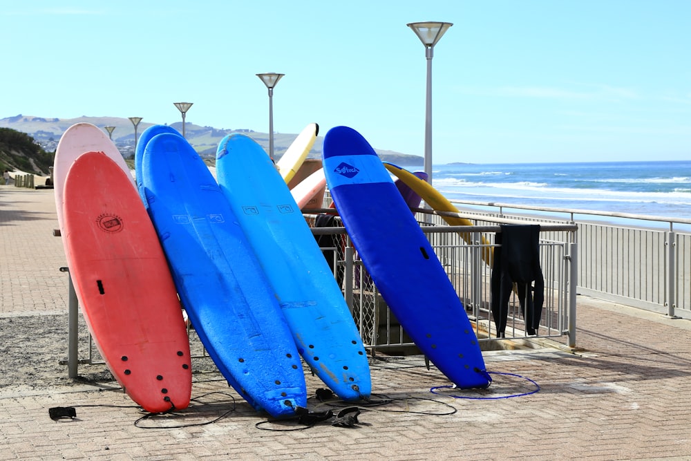 verschiedenfarbige Surfbretter, die sich auf eine Metallschiene stützen