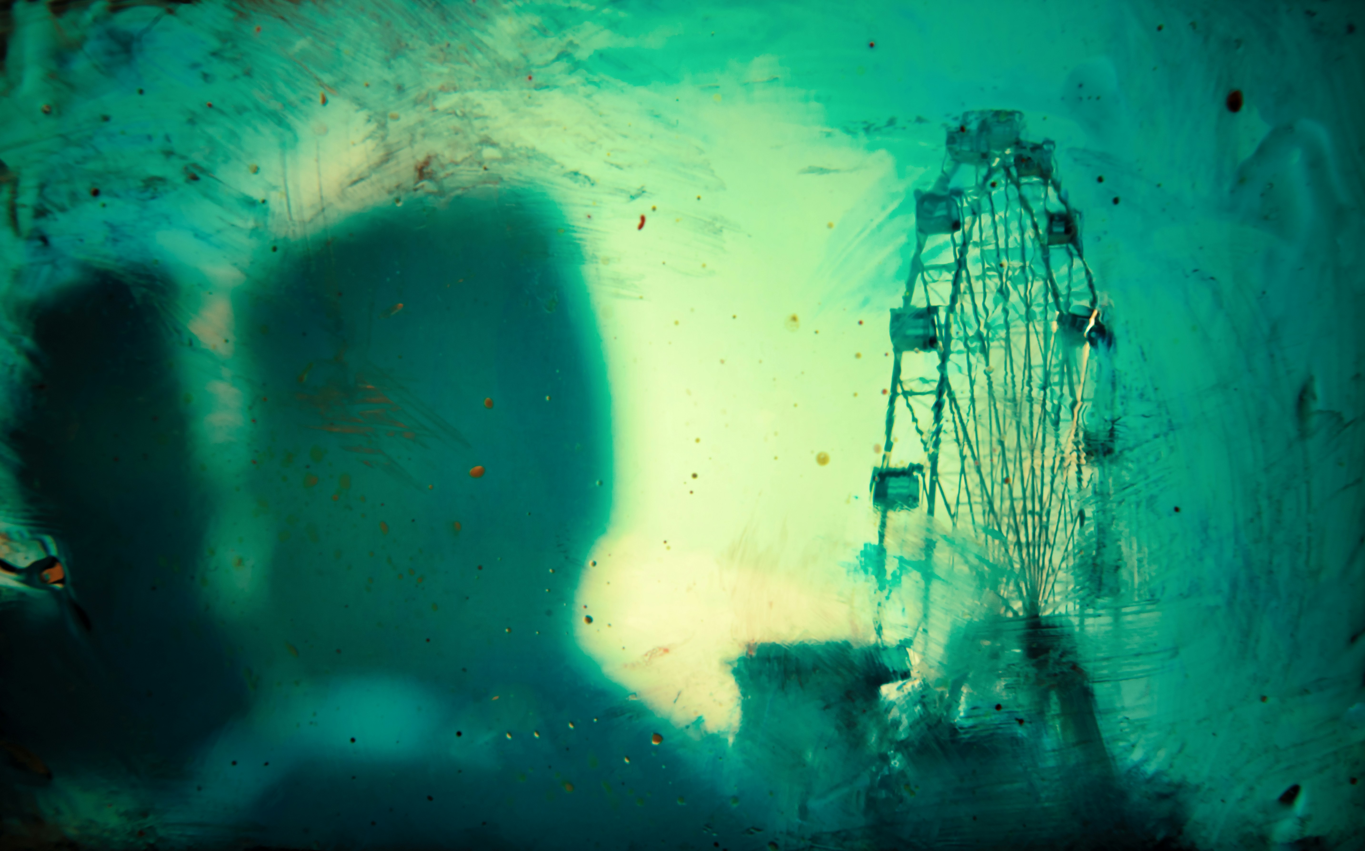 a ferris wheel is seen through a dirty window