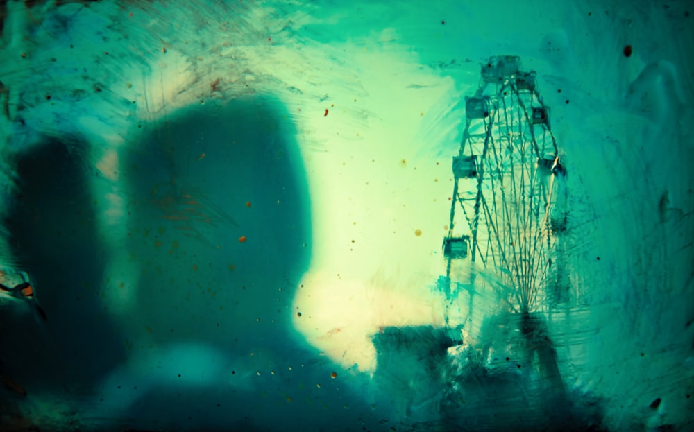 a ferris wheel is seen through a dirty window