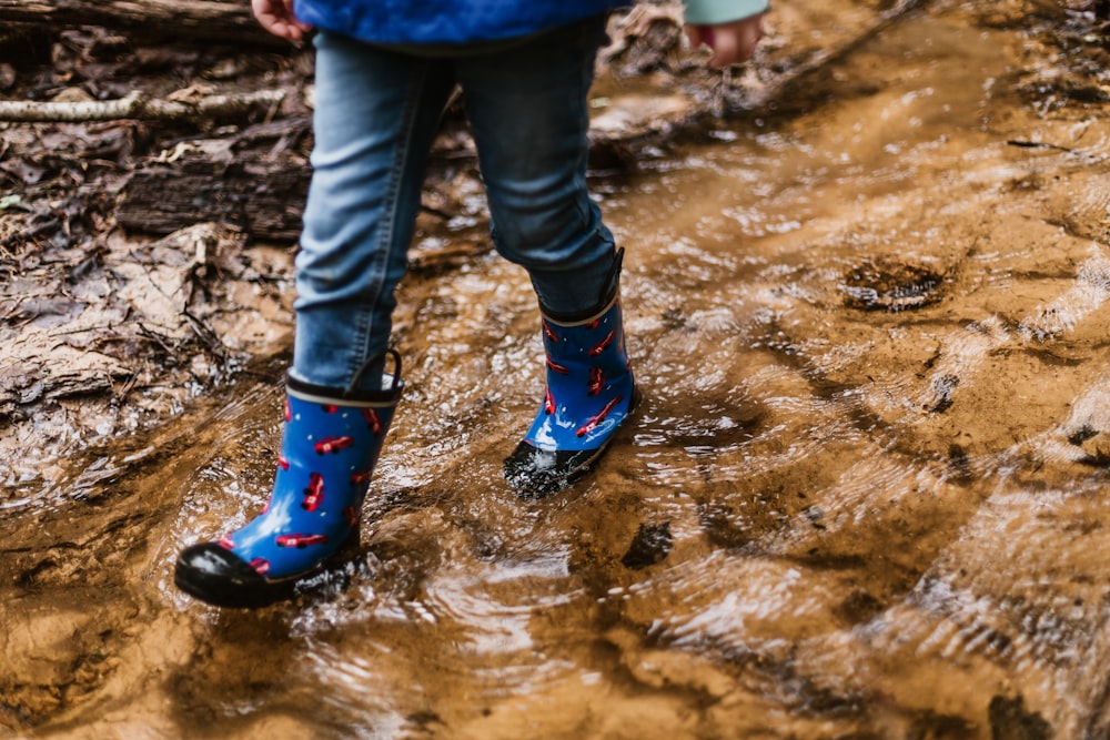 person wearing blue-and-red rain boots