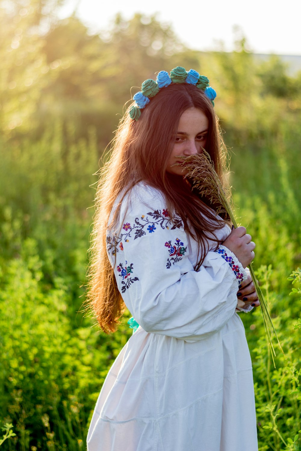 a woman in a white dress standing in a field