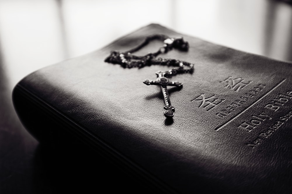 selective focus photography of rosary on top of bible