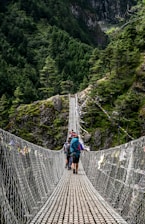 people walking on grey rope bridge during daytime