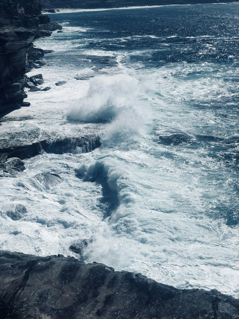 Landschaftsfotografie von Meereswellen, die an Felsen brechen