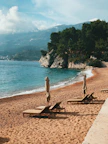 empty outdoor loungers near shore