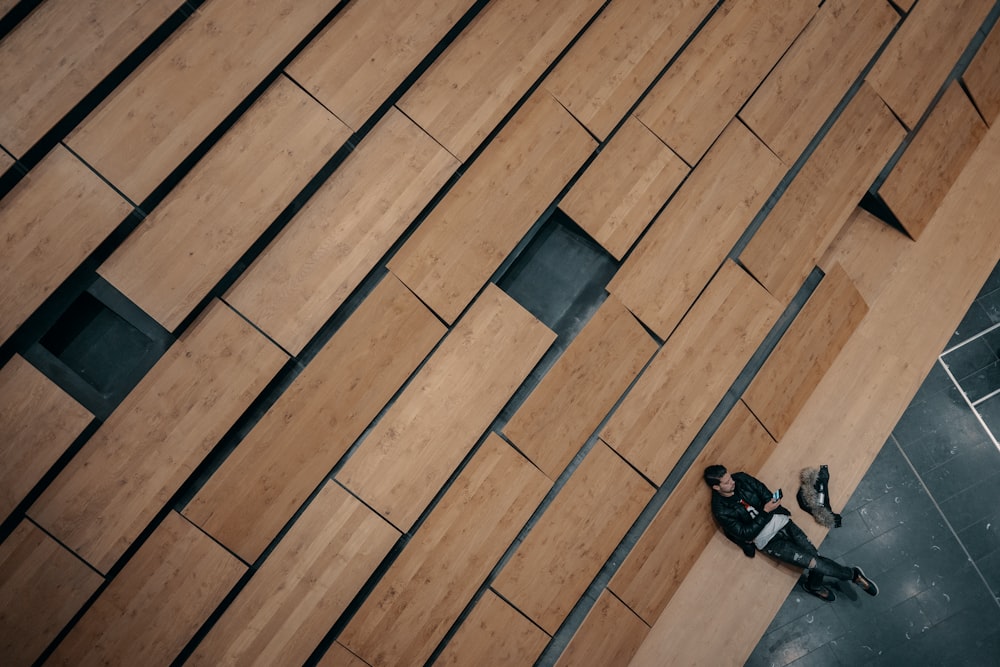 a man sitting on the ground next to a tall building