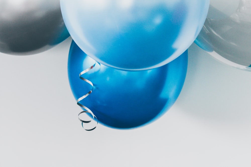 four gray, blue, and white balloons hanged on wall