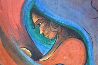 A stylized depiction of a woman with a serene expression gazes lovingly at a child nestled in her arms. Bold, vibrant colors create a sense of warmth and intimacy, with swirling lines outlining the figures.