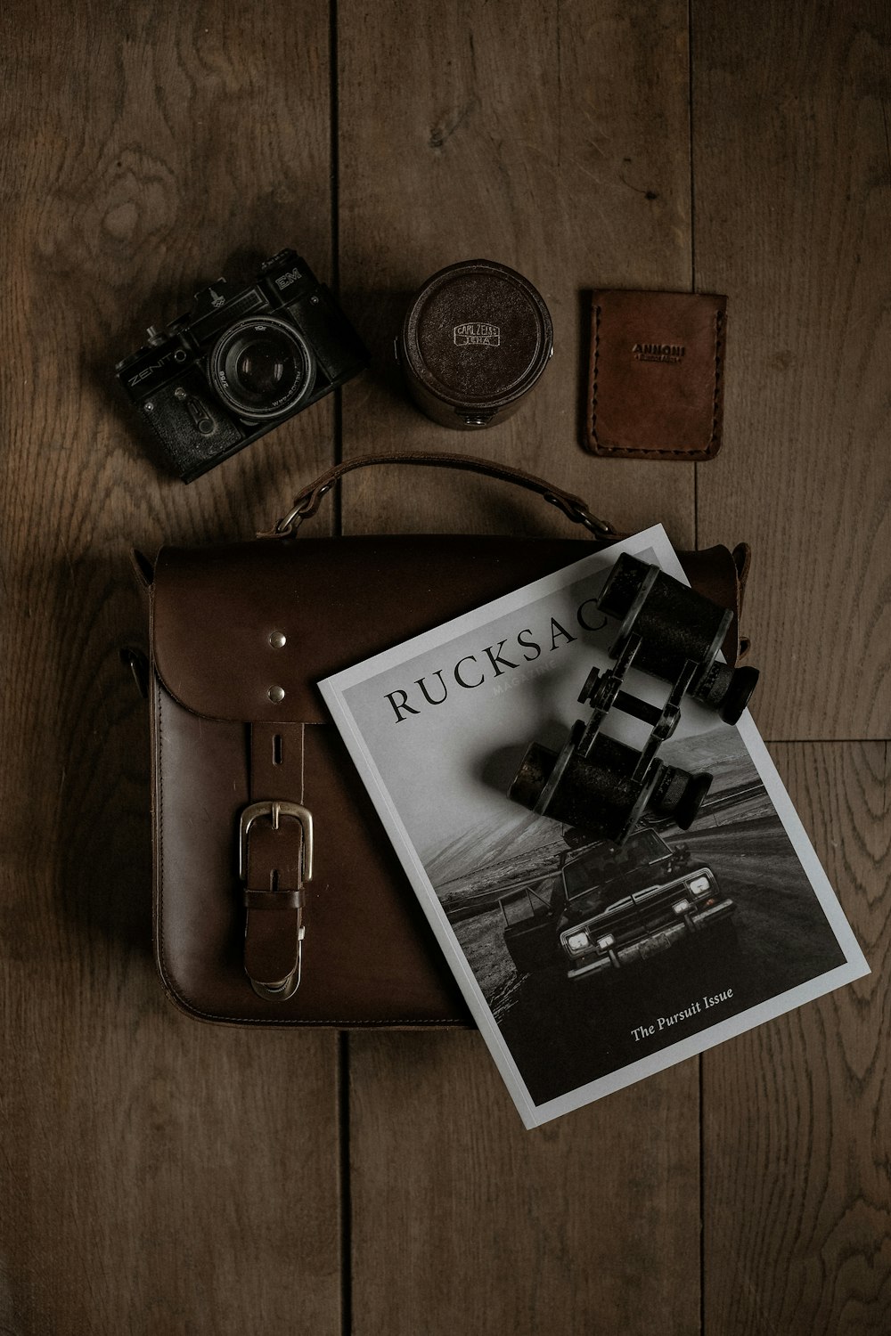 un appareil photo et un livre sur un plancher en bois