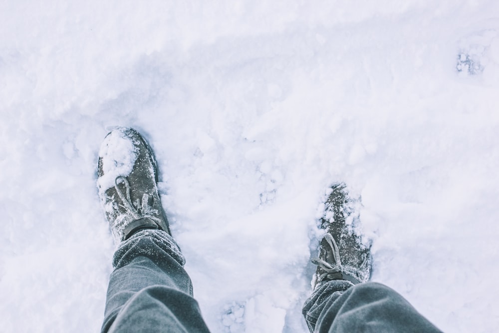 a person standing in the snow with their feet in the snow