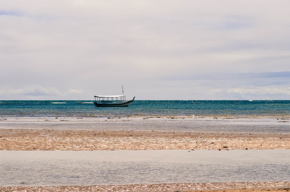 white and black boat on sea under white and blue skies