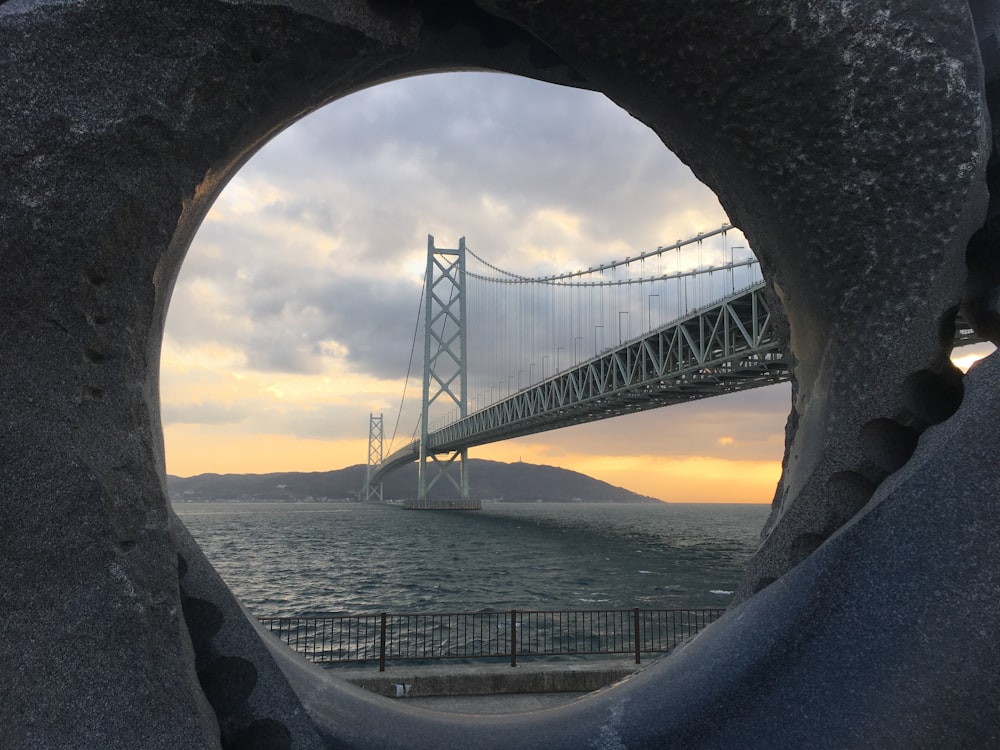 a view of a bridge through a hole in a rock