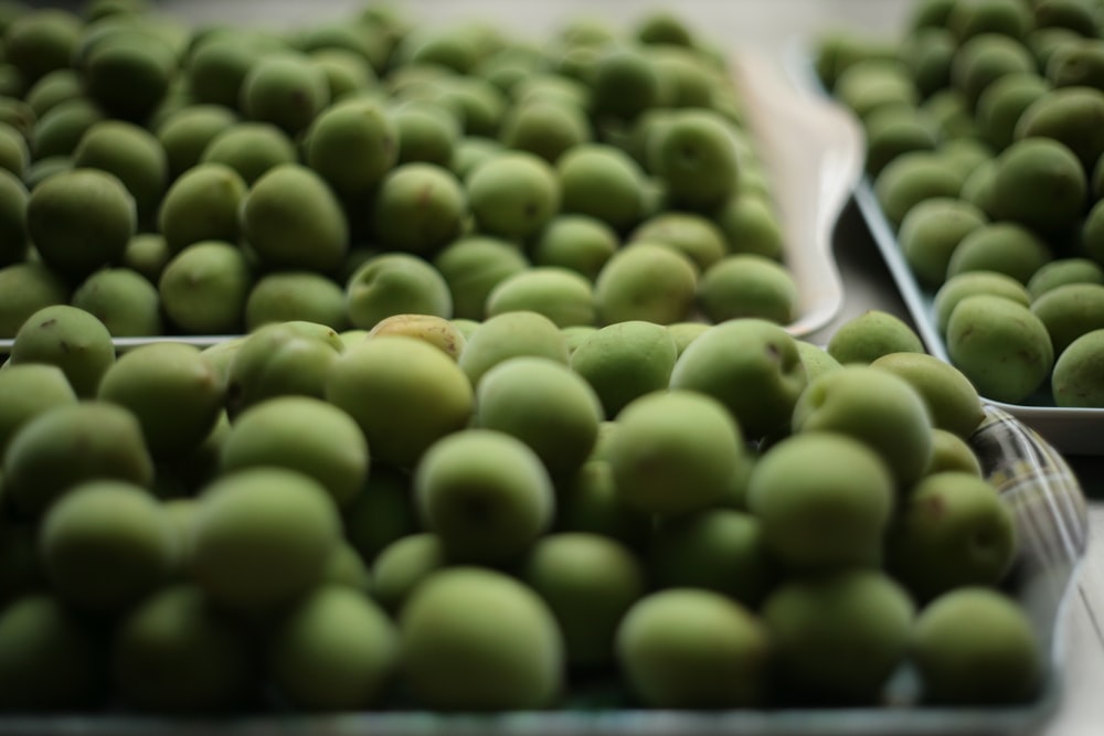 lots of green olives on three trays