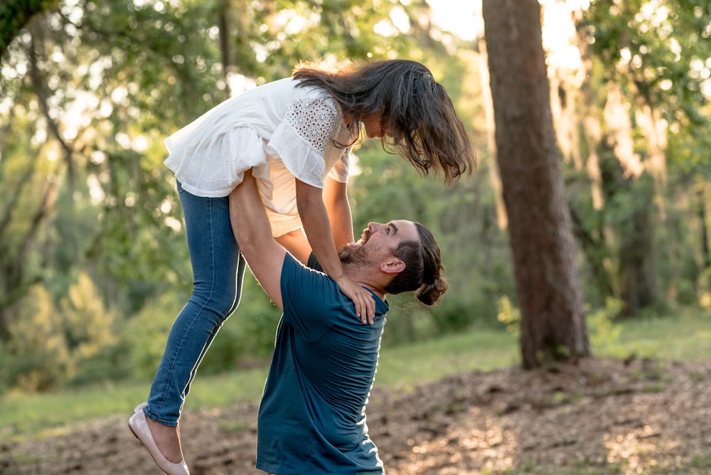 man holding girl near tree