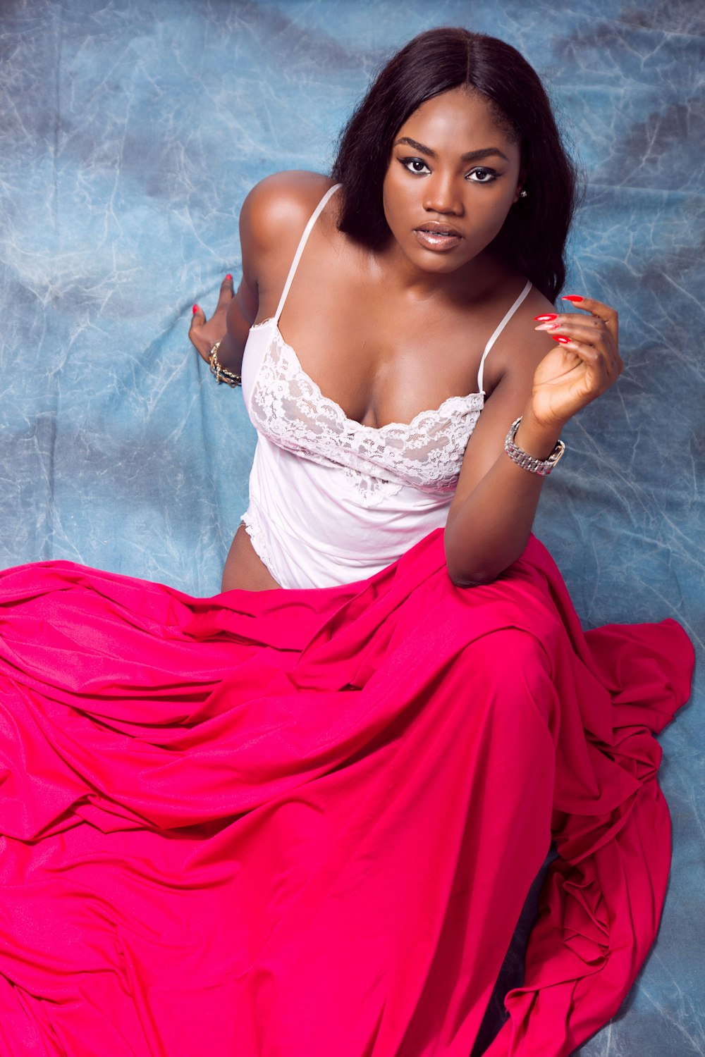 woman in white babydoll sitting on blue surface