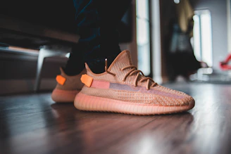 Close-up of colorful tri-star rubber sneakers arranged on a wooden floor.