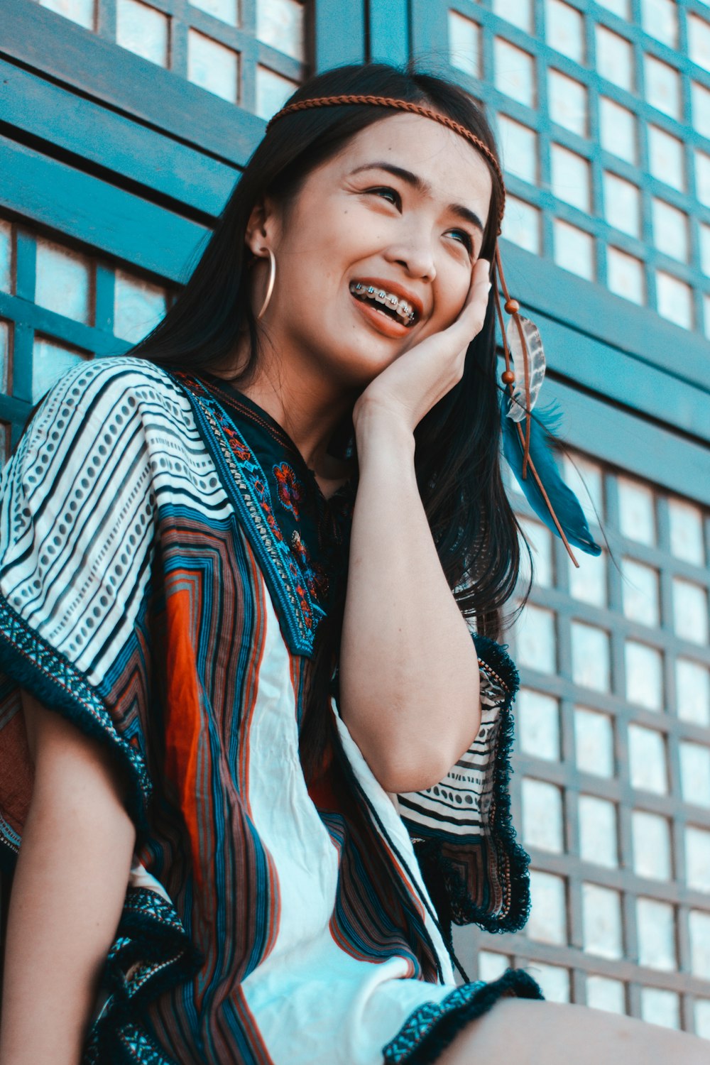 woman sitting and smiling near wall