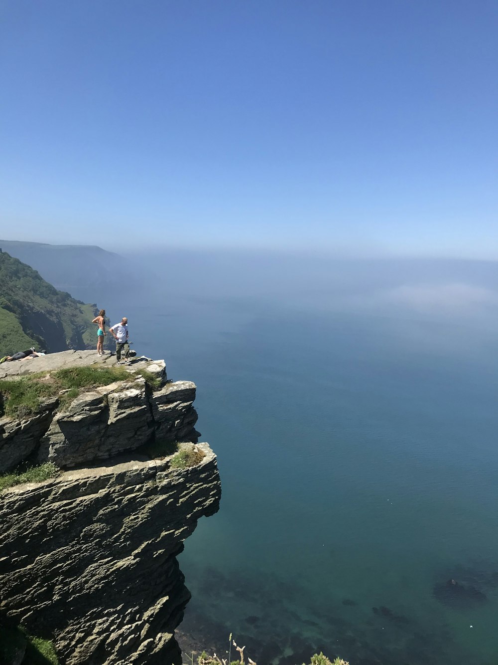 two persons standing on cliff