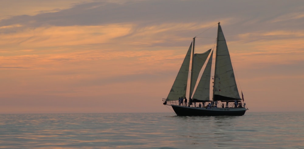 white and black boat sailing on sea