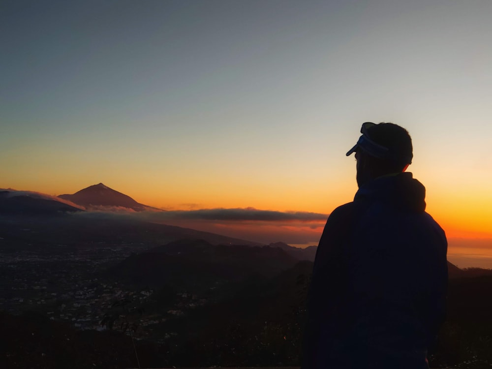 a person standing on top of a hill at sunset