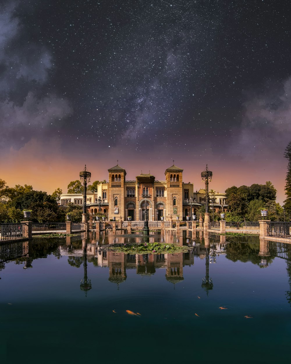 Un gran edificio sentado en la cima de un lago bajo un cielo nocturno