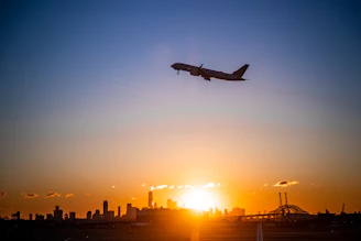 A sleek airplane soaring above a glowing city skyline at dusk, symbolizing global connectivity.