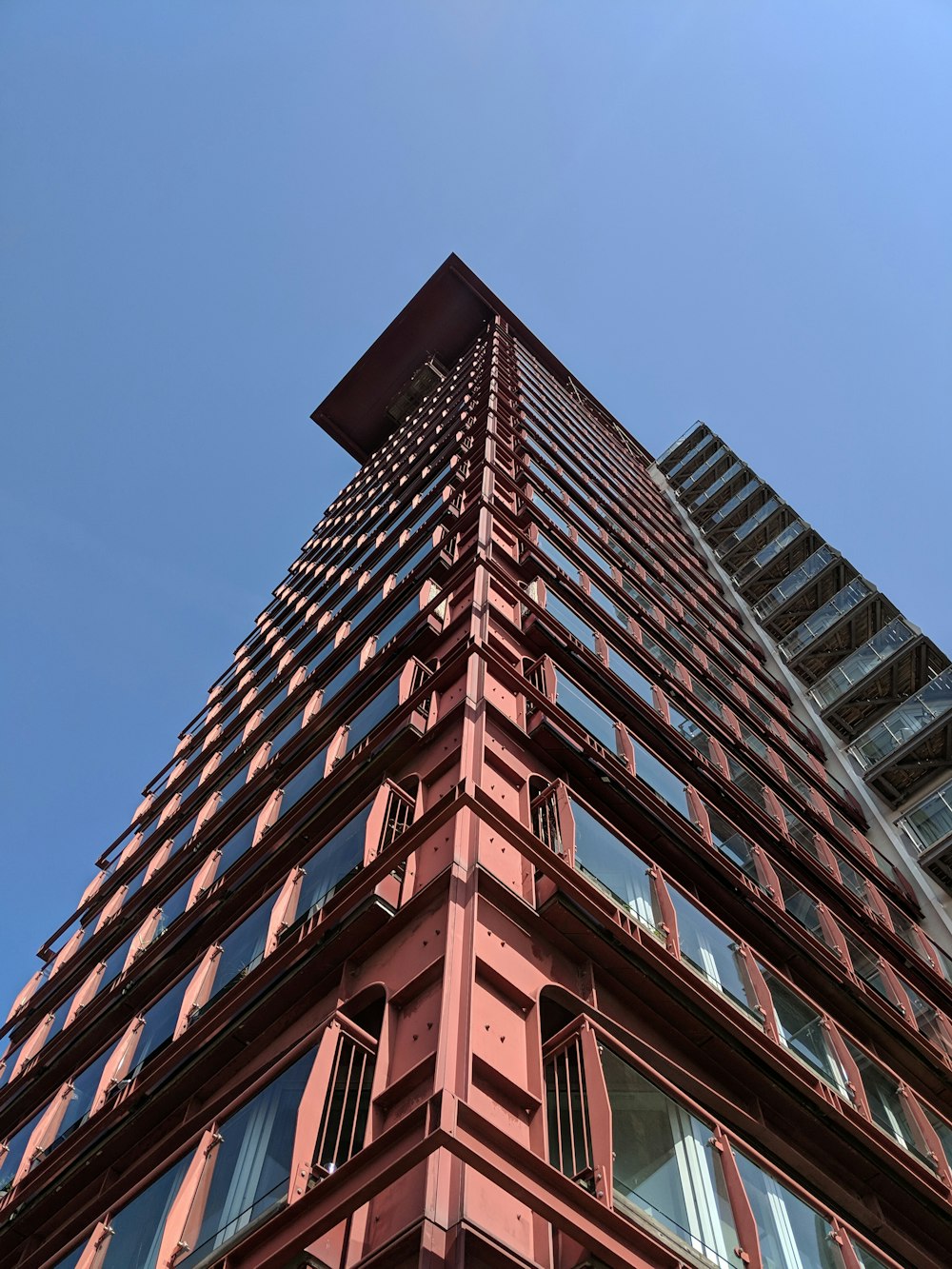 Fotografía de ángulo bajo de un edificio de gran altura rosa