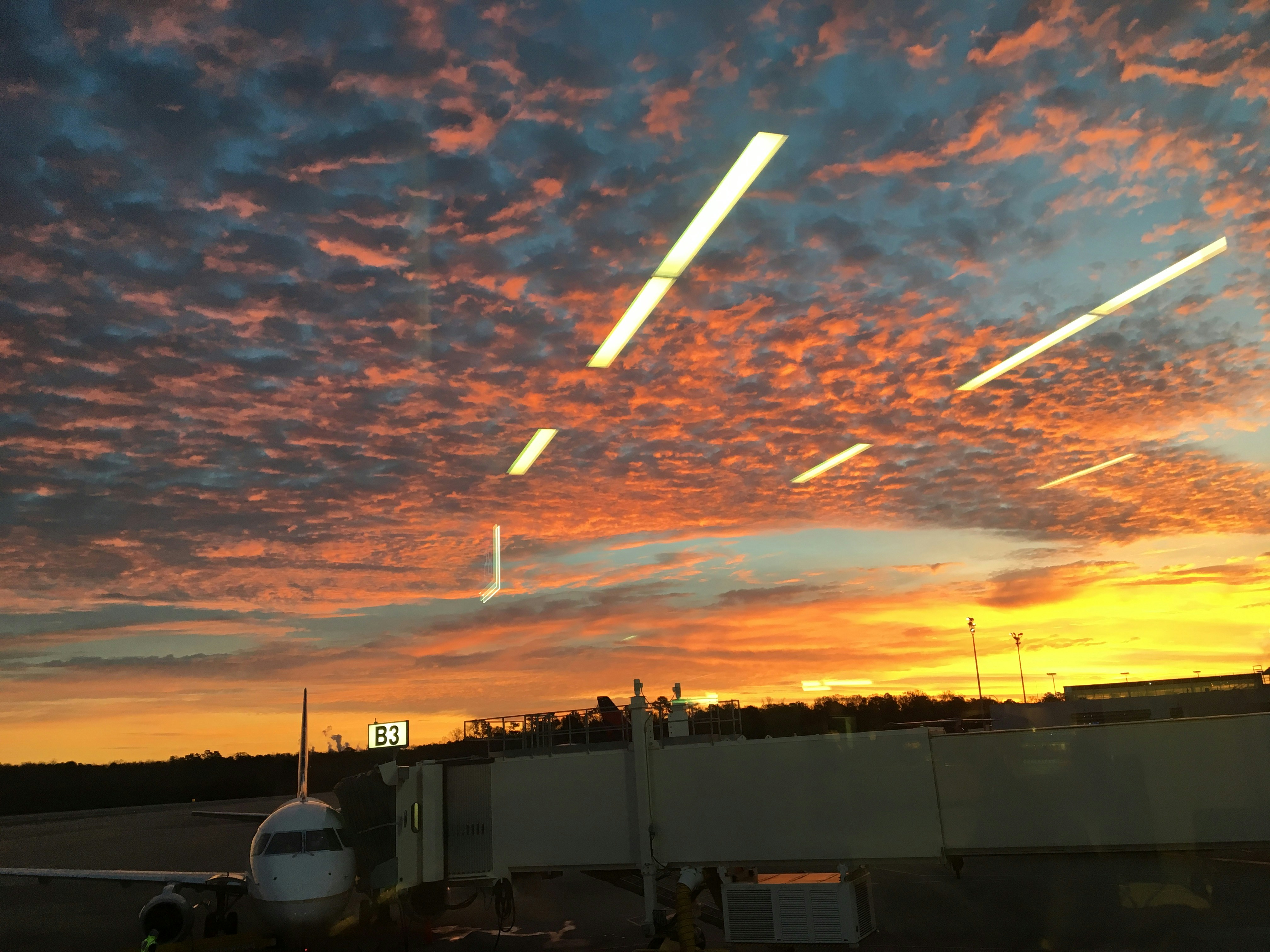 A stunning aerial view of a vibrant sunset over a bustling airport.