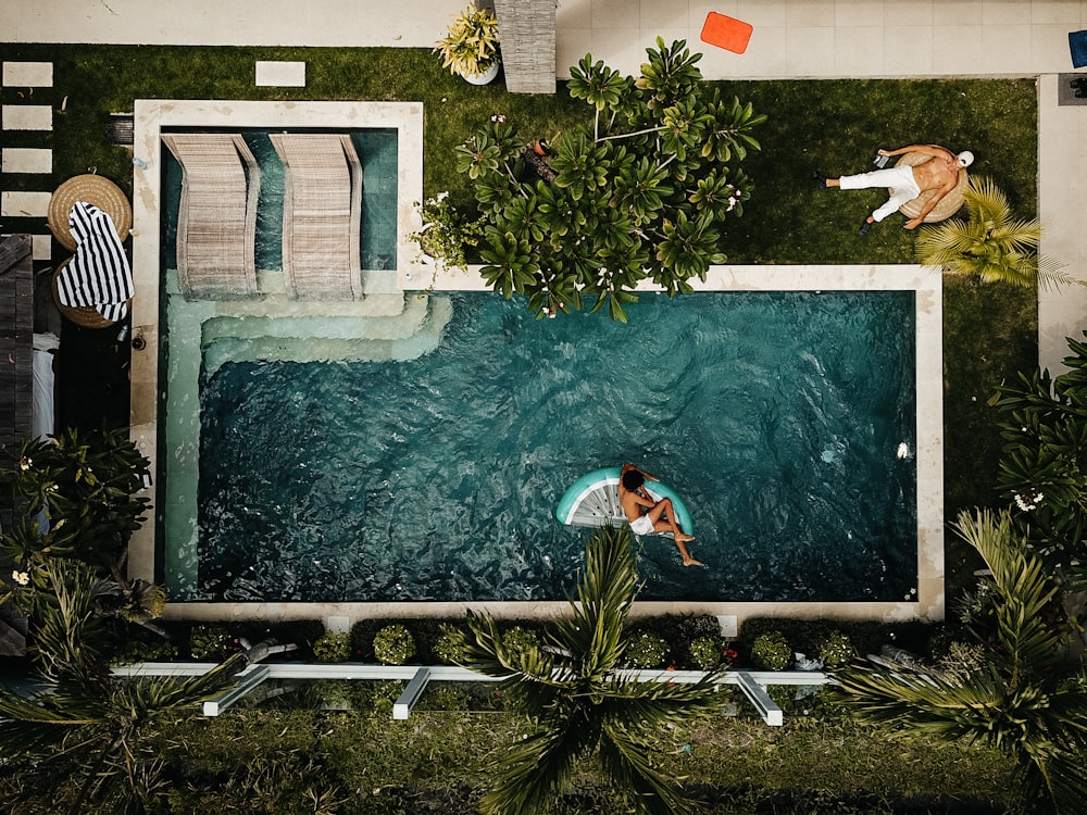 person swimming on pool at daytime