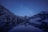 A serene landscape with a starry night sky over a calm lake.