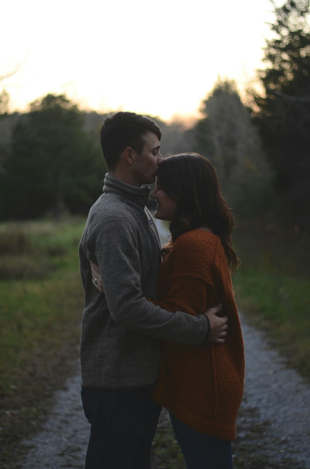 man kissing wman's forehead