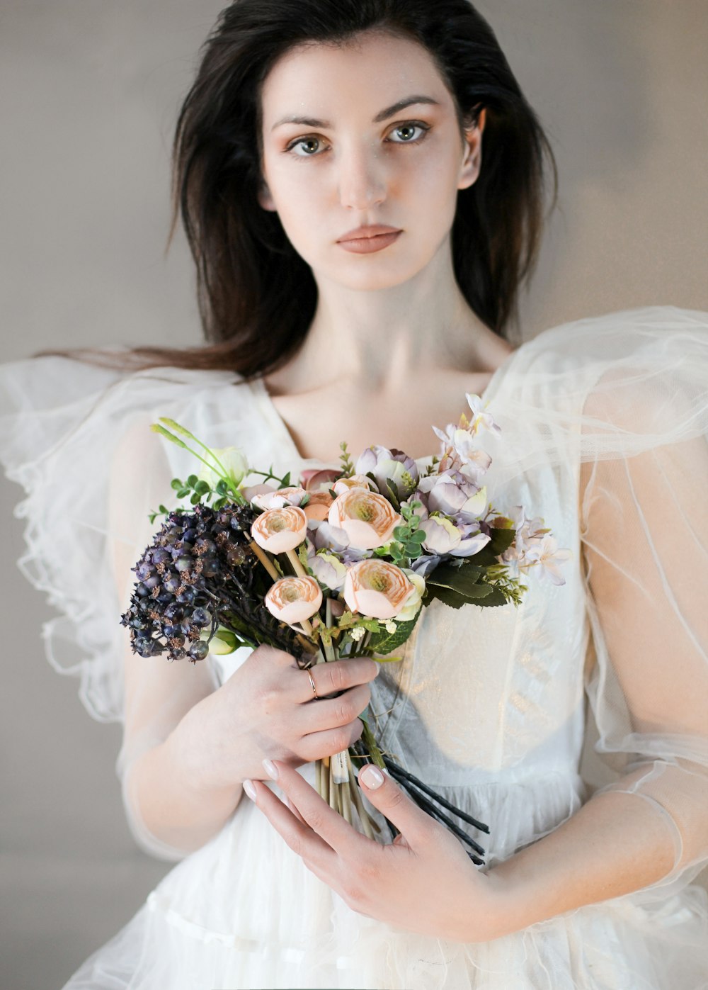 꽃다발을 들고 있는 흰색 웨딩 드레스를 입은 여자