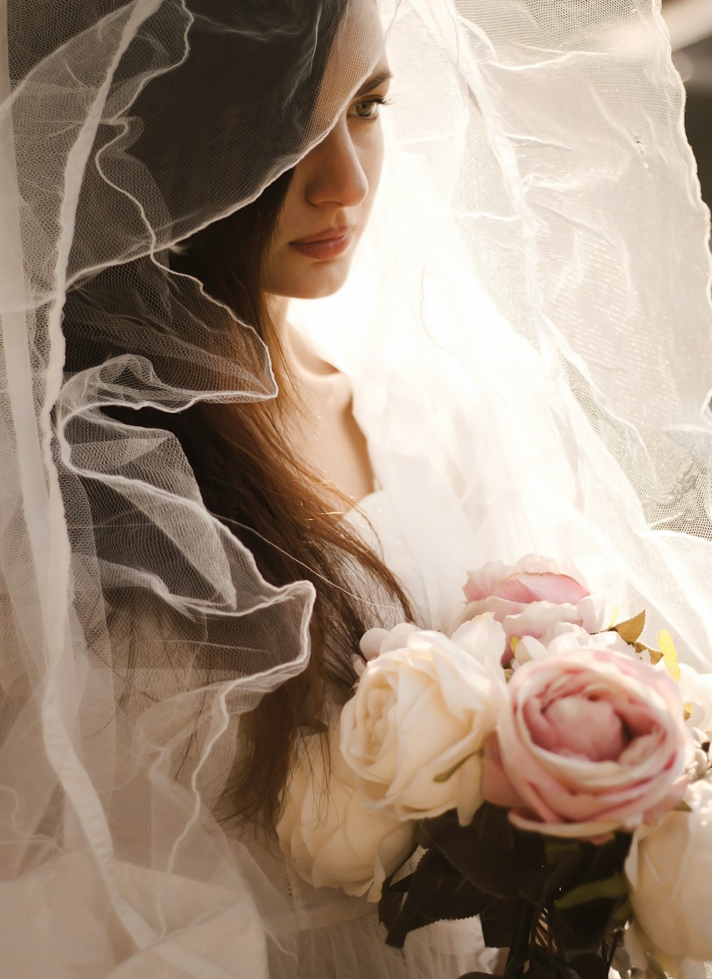 femme portant une robe de mariée tenant un bouquet de fleurs