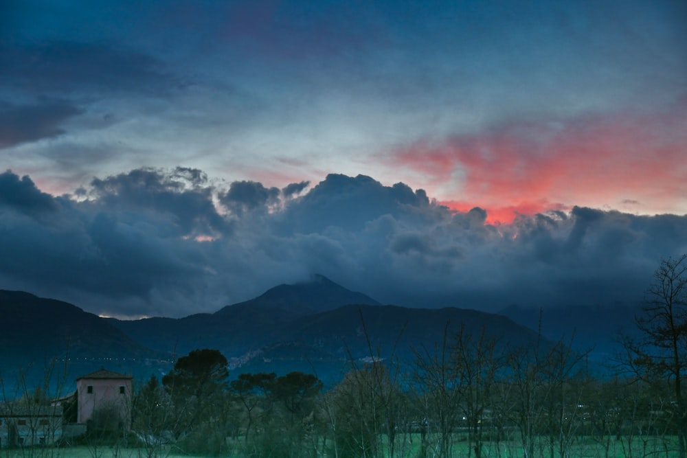 a cloudy sky with mountains in the background