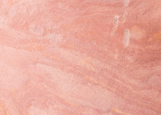 a skateboarder is riding on a pink surface