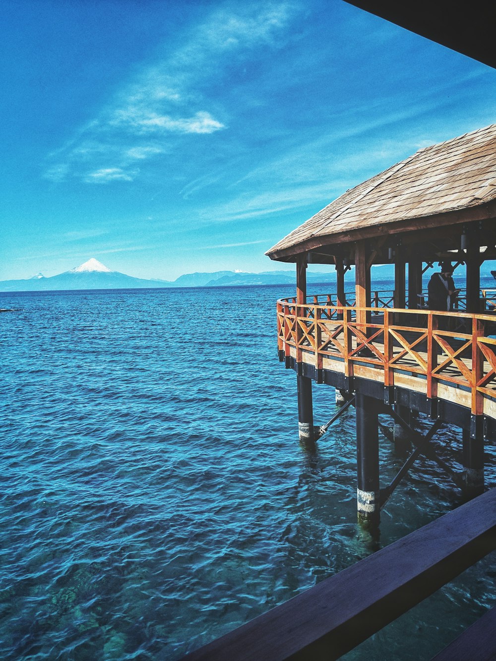 a pier with people standing on it in the water