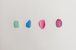 four green, blue, and pink paints
