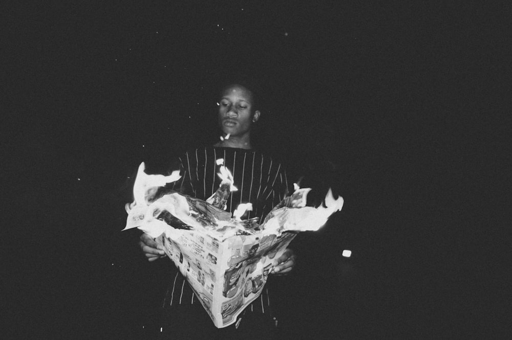 grayscale photo of man holding paper