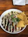 A bowl of creamy chipotle sauce surrounded by fresh ingredients like chipotle peppers and herbs.