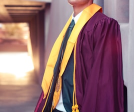 man standing while wearing purple academic gown