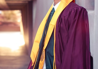 man standing while wearing purple academic gown