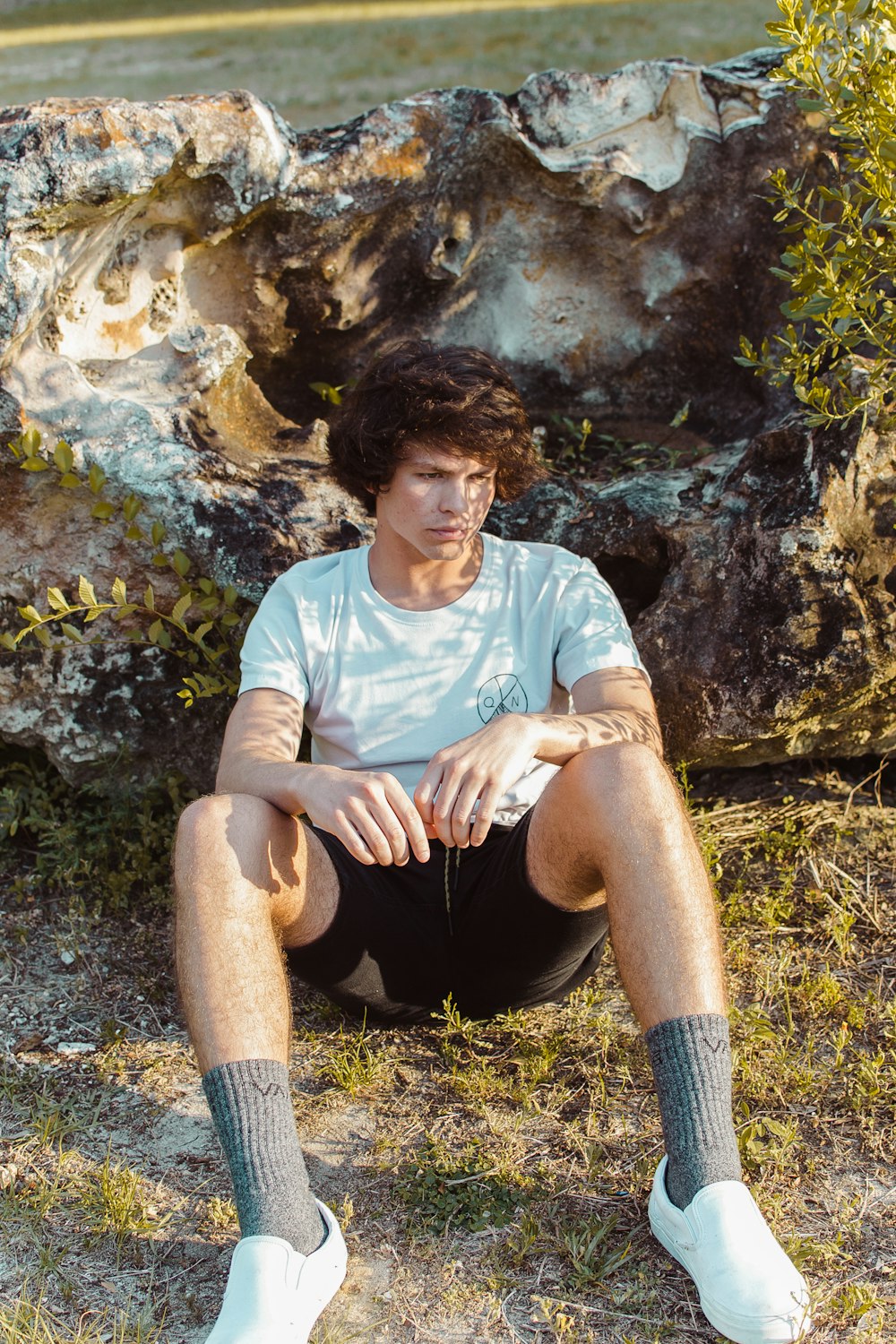 man sitting against rock