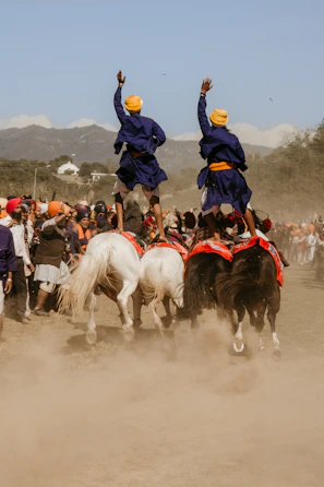 two person standing on white horses surrounded with people
