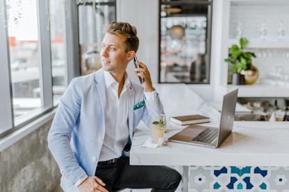 man sitting beside white wooden table