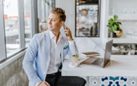 man sitting beside white wooden table