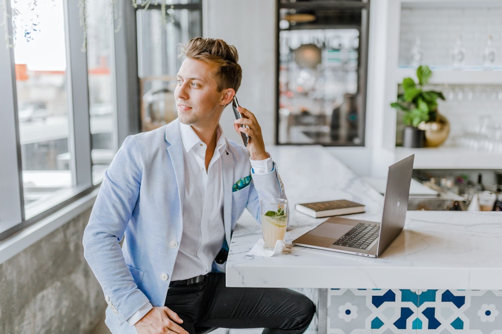 man sitting beside white wooden table