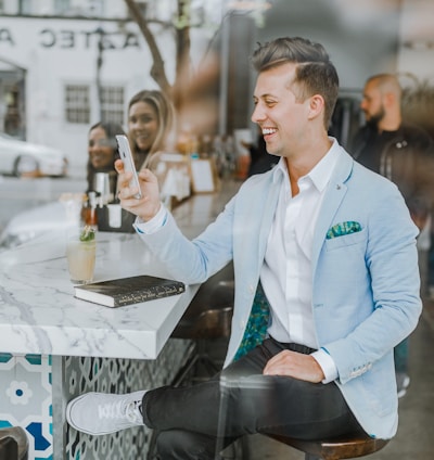 smiling man while holding smartphone