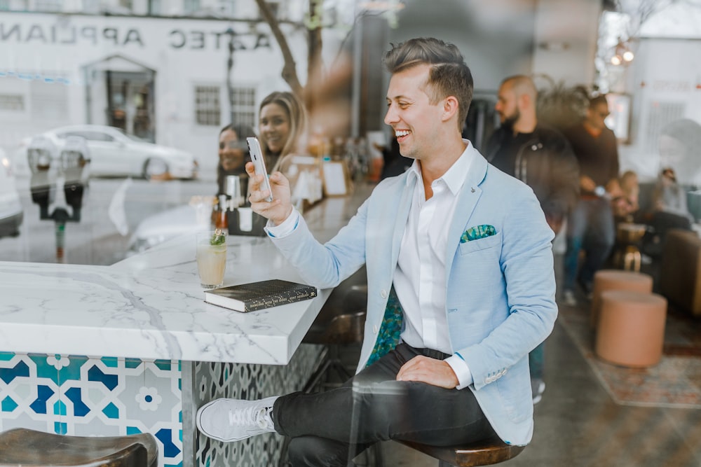 smiling man while holding smartphone - customer loyalty program