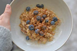 Hands holding a warm bowl of two oaks oat meal, ready to enjoy.
