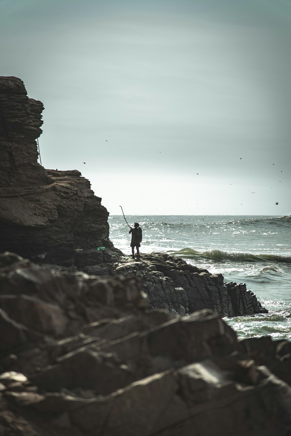 silhouette of person standing on rock formation